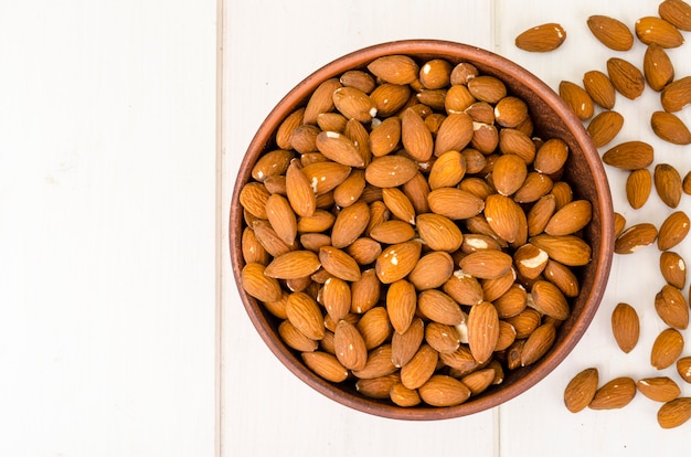 Lots peeled almonds in wooden bowl. Photo