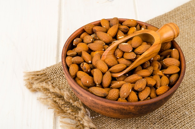 Lots peeled almonds in wooden bowl. Photo