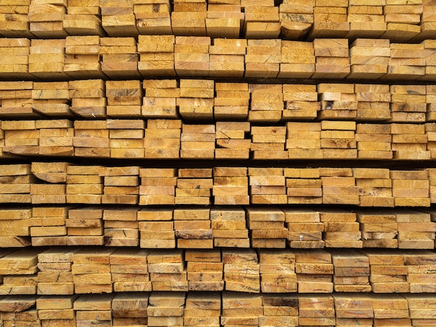 Lots of planks stacked on top of each other in the warehouse. Lumber for further use in construction