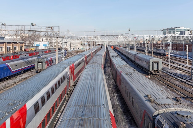 Lots of railway tracks with standing trains on a sunny day against a blue sky in an industrial city Top view