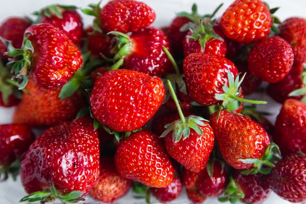 Lots of red ripe strawberries with green tails