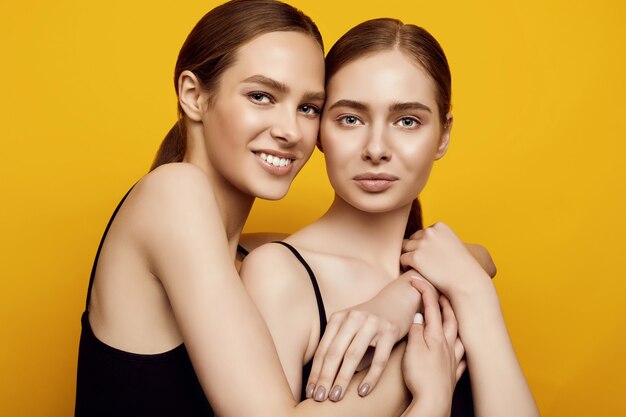 Lovable two caucasian girls expressing positive emotions