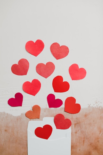 Love background with paper hearts and red ribbon on white background