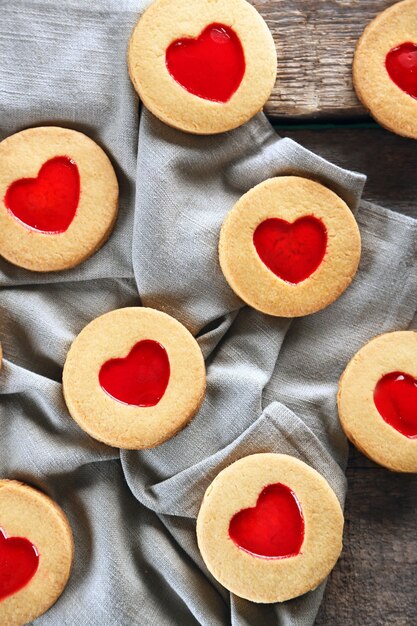 Love cookies with grey cloth on wooden surface, closeup