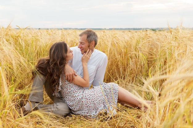 Love couple hugs together on a wheat field. Man and woman on summer meadow. Romantic date