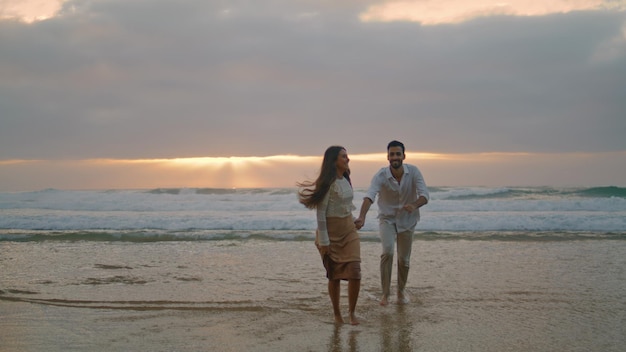 Love couple running ocean beach sunset together ethnic lovers enjoying on date