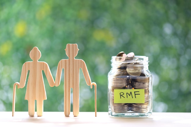 Love couple senior with coins money in glass bottle on natural green background