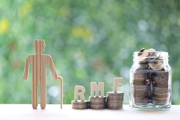 Love couple senior with RMF word on stack of coins money on natural green background