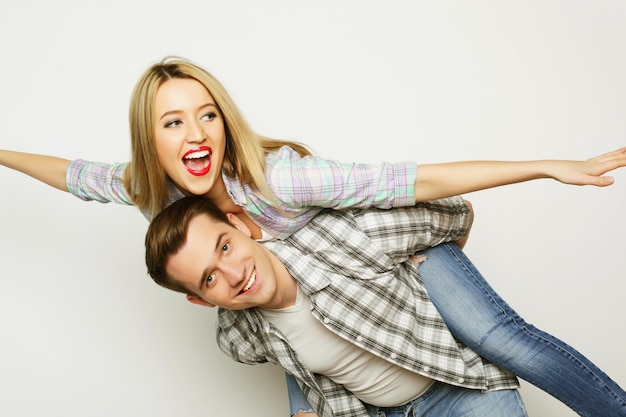 Love, family and people concept:   lovely couple,  young man carrying girlfriend on his back.