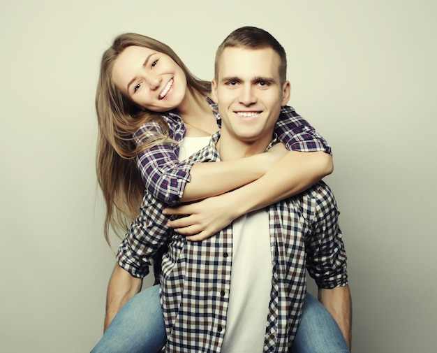 Love family and people concept lovely couple young man carrying girlfriend on his back