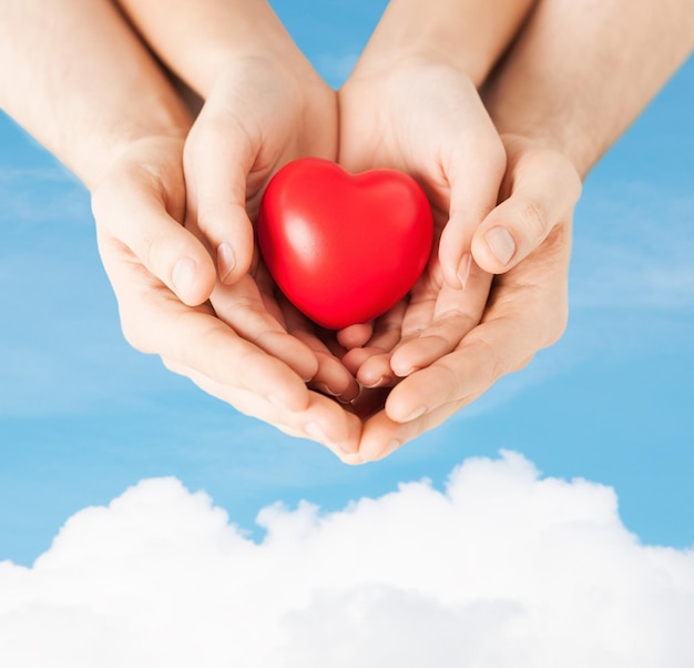 love, family and relationships - closeup of woman and man hands with heart