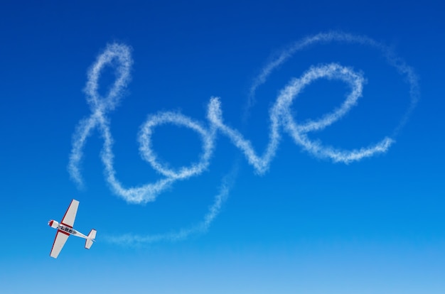 Love figurative inscription from a white smoke trail airplane.