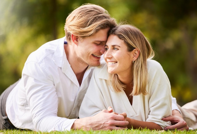 Photo love grass and park with a couple lying together on a field for romance or affection during a date spring nature or peace with a young male and female bonding while enjoying a summer picnic