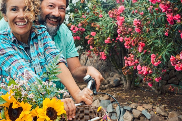 Love and happiness with long time relationship between man and woman having fun together riding a bike in spring Outdoor people leisure activity Couple enjoying time with joy and smiles outside