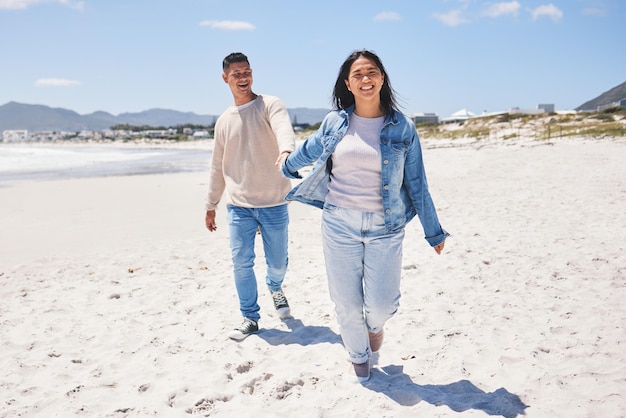 Love happy and holding hands with couple at beach for travel summer vacation and romance together Smile relax and bonding with man and woman walking on seaside holiday for care date or honeymoon