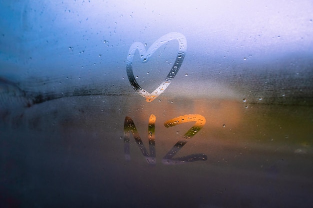 Photo love heart symbol on window with the letter nz and vapor condensation