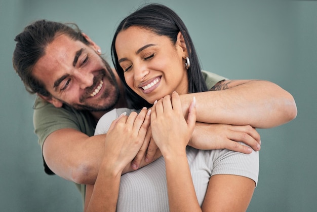 Love hug and support of a couple in a home with smile care and affection Trust help and embrace of marriage or young interracial people comforting partner together in their house with happiness