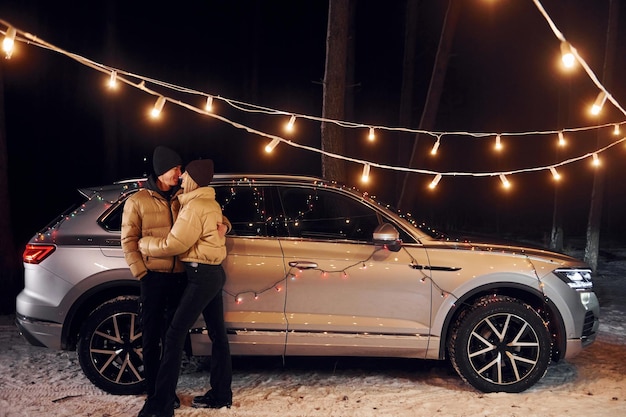 Love and hugs Couple standing in the forest and celebrating New year