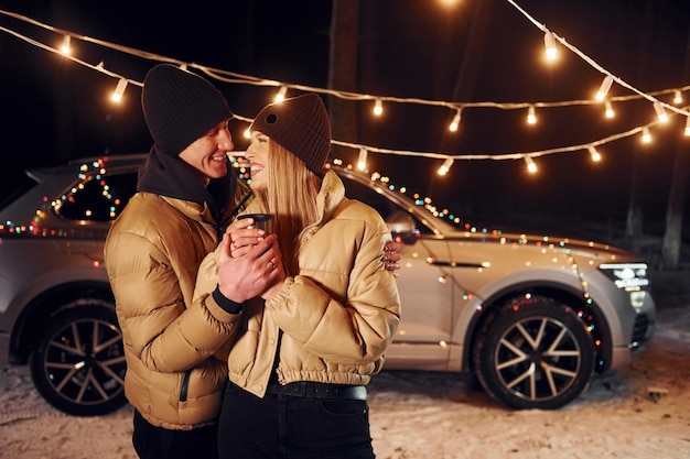 Love and hugs Couple standing in the forest and celebrating New year