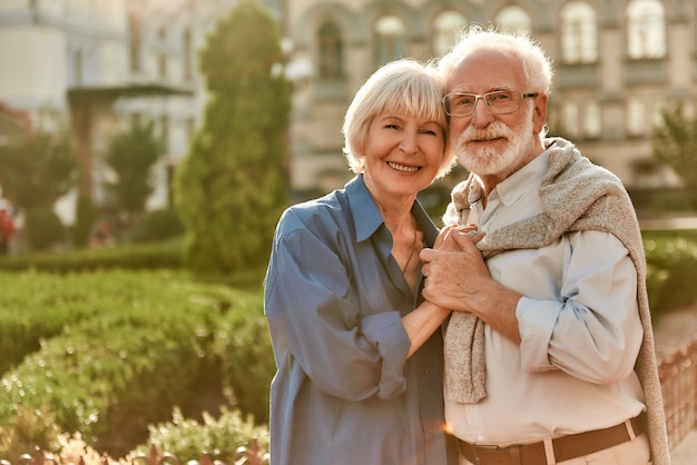 Love is life portrait of cheerful happy senior couple bonding to each other and holding hands while