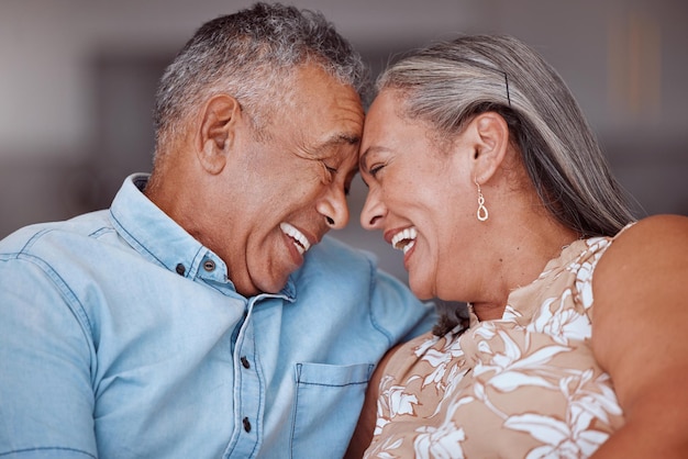 Love laugh and happy elderly couple relax and bond in a living room laughing and sharing a funny joke in their home together Family humour and senior man and woman embrace and enjoy retirement