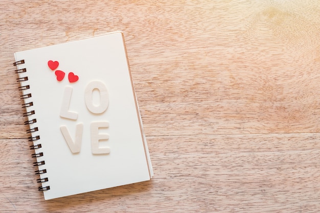 love Letter with notebook on wooden board background with copy space.