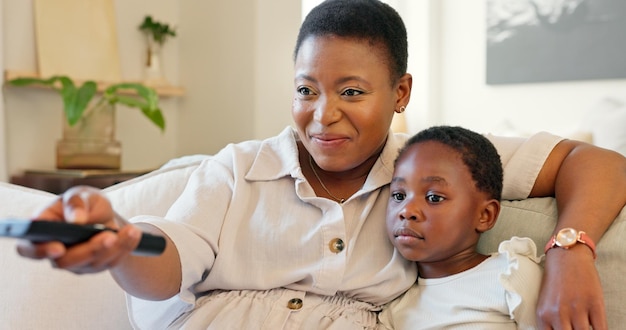 Love mother and girl streaming a movie while relaxing on a sofa in the modern living room Happy smile and black family watching a film online in lounge while bonding talking and resting together