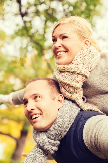 love, relationship, family and people concept - smiling couple having fun in autumn park