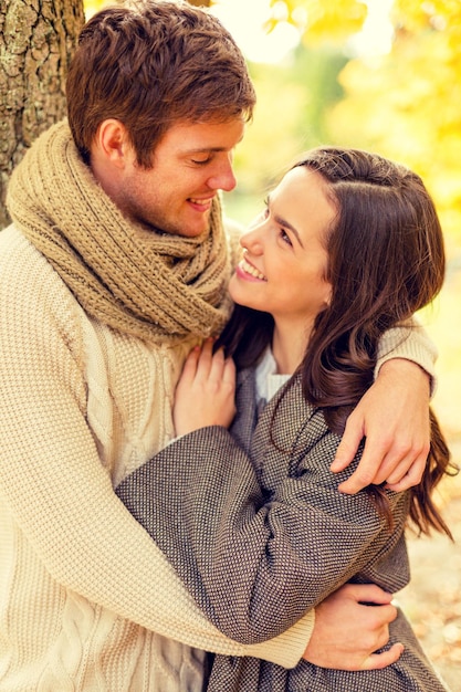 love, relationship, family and people concept - smiling couple hugging in autumn park