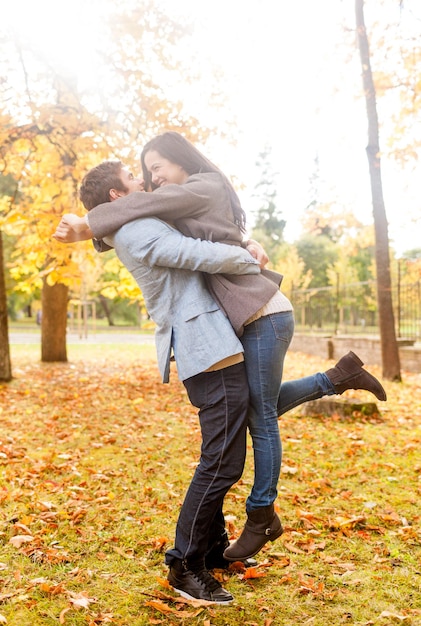 love, relationship, family and people concept - smiling couple hugging in autumn park