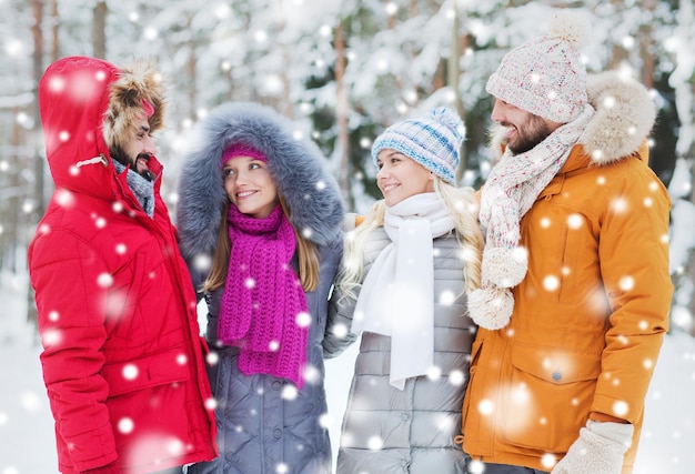 love, relationship, season, friendship and people concept - group of smiling men and women talking in winter forest