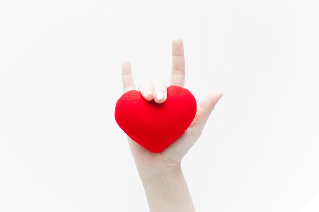 Photo love sign by woman hand and red heart shape on white background closeupsymbol of love or dating valentines day