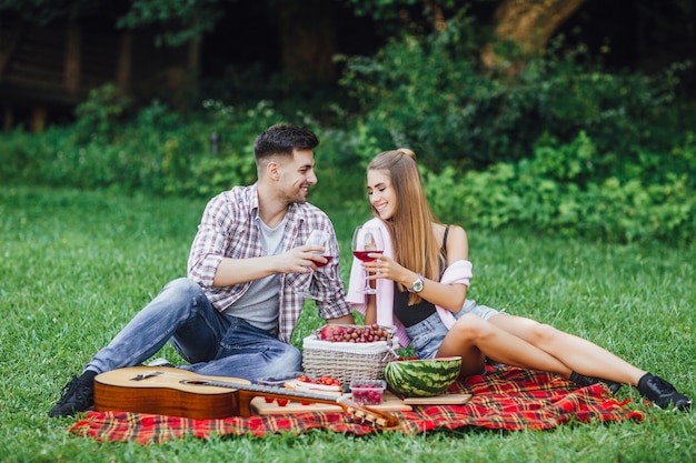 Love story.Beautiful couple enjoying picnic time outdoor,they are sitting in blanket carpet