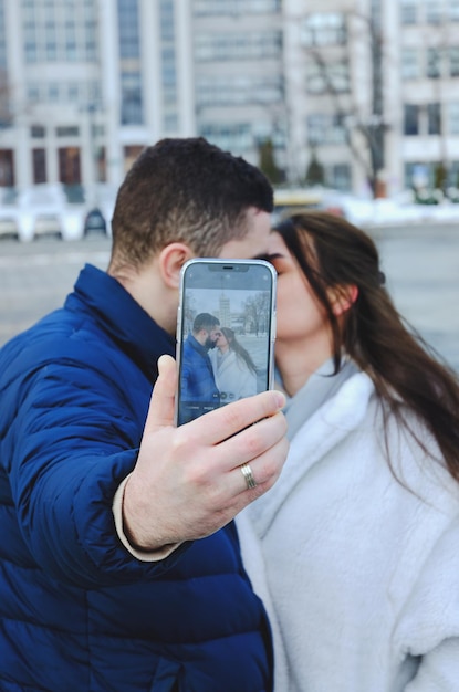 Love story of couple walking. City. Young man in blue jacket, beard. Cute woman in white coat. Date