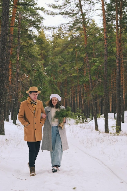 Love story of funny couple in snowy white city, park: young man, woman. Family winter holiday, date