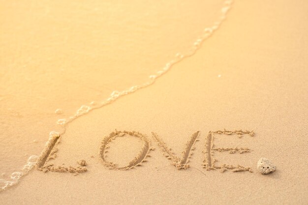 Photo love text on sand at beach