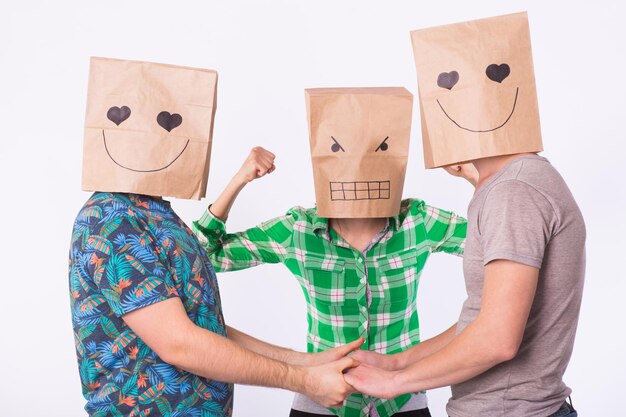 Love triangle, jealousy and homosexuality concept - gays with bags over heads holding hands and another woman is angry.