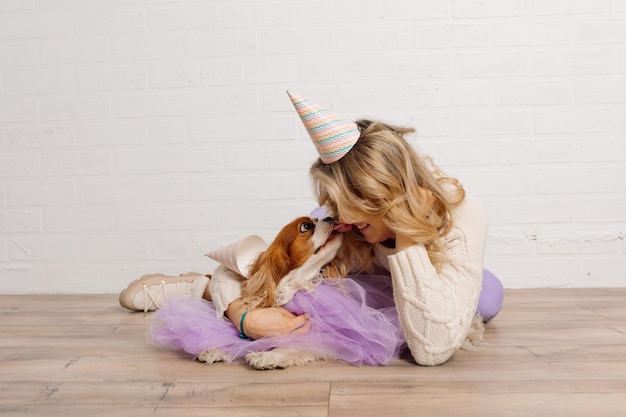 Love and trust shows cavalier king charles spaniel dressed in lilac cape to his mistress during phot