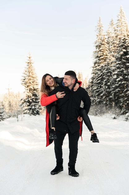 Love and vacation concept  happy couple hugging and laughing outdoors in wintercouple in nature