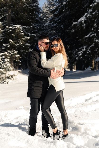 Love and vacation concept  happy couple hugging and laughing outdoors in wintercouple in nature