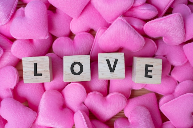 LOVE wooden cubes with pink heart shape decoration on blue table background and copy space for text. Love, Romantic and Happy Valentineâs day holiday concept