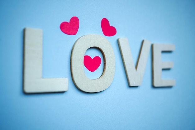 love wooden letters and heart shapes on the blue background for valentine's day