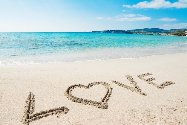 Love written on a tropical beach on a clear day