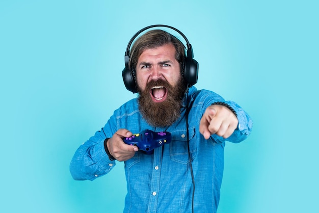 Love your Game More new technology in modern life digital living hipster with console bearded man wearing headphones concept of online gaming audio game guide play computer game