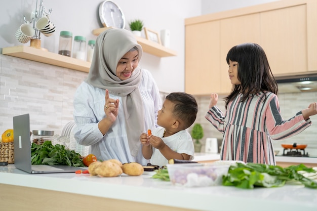 Lovely asian woman with daughter and son cooking dinner