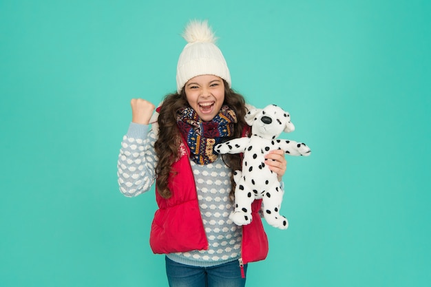 Lovely baby smiling face. Pets shop. Her favourite toy. Happy child hold soft toy. Little girl smile with toy dog. Dreaming about real dog. Kids toy shop or store. Winter style. Childhood fun.