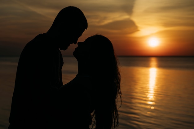 Lovely beautiful couple in love at dawn close-up look into each other's eyes and smile.