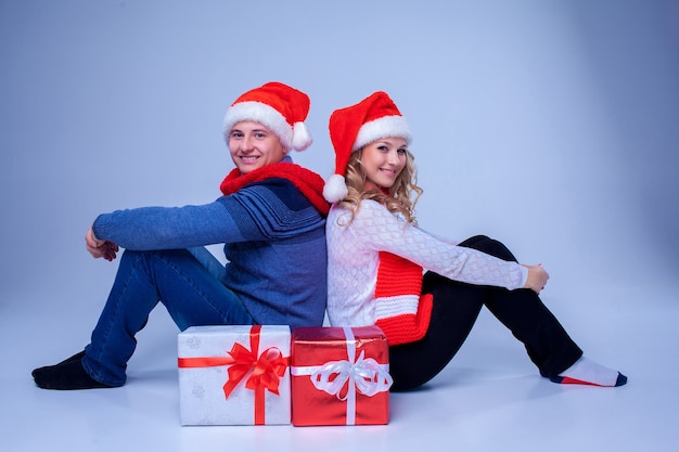 Lovely christmas couple sitting with presents