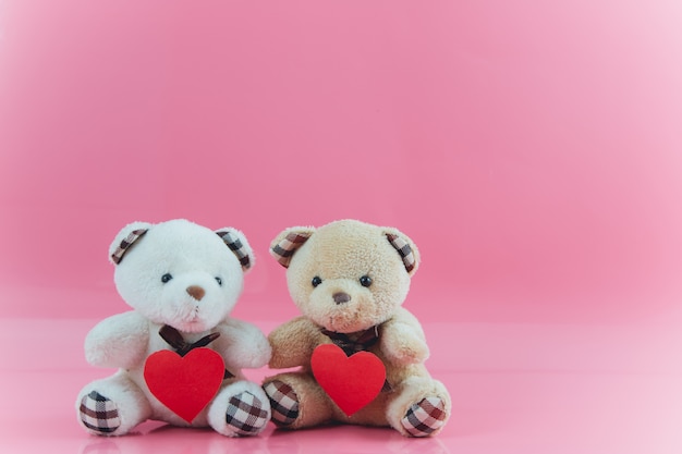 Lovely couple bear hold heart with pink background