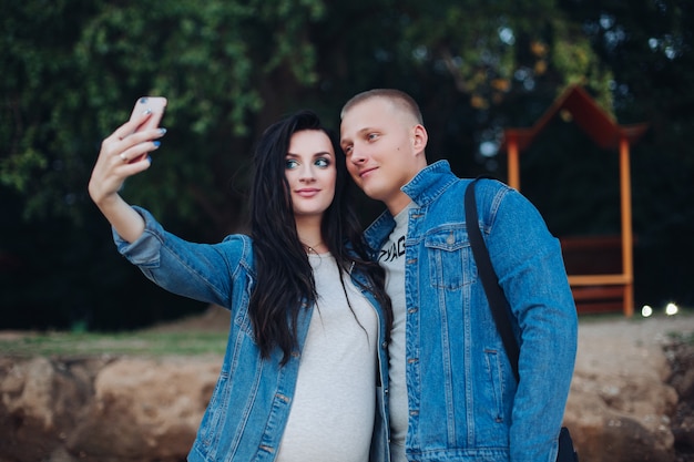 Lovely couple walking in park and taking selfie together